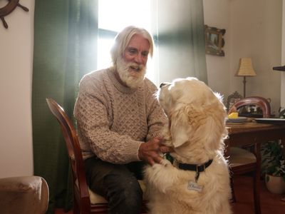 An older man playing with his dog